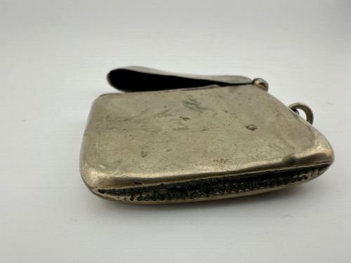 fig 4. An antique rectangular silver-plated vesta case featuring hand-engraved scrollwork, an open hinged lid, and a side suspension ring.