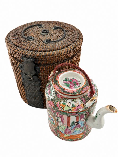 fig 1. A Chinese Famille Rose cylindrical ceramic teapot with hand-painted court figures set beside its fitted woven wicker carrying case.