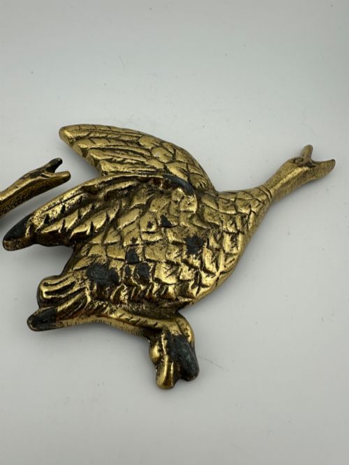 fig 2. A set of three graduated cast brass flying geese wall plaques arranged by size with textured feather detailing.