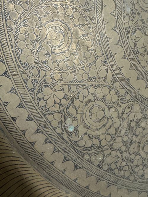 fig 2. A large circular brass tray featuring intricate hand-engraved concentric floral and geometric patterns with a shallow rolled rim.