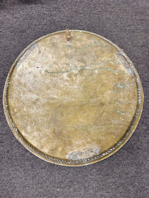 fig 3. A circular antique brass tray featuring an intricately engraved swirling floral pattern and a pierced gallery rim.
