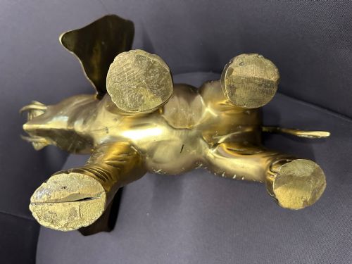 fig 4. A solid brass sculpture of an elephant standing with its trunk raised up.