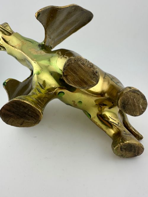 fig 11. A solid cast brass elephant sculpture with an elevated raised trunk, detailed engraving along the body, and a polished gold finish.
