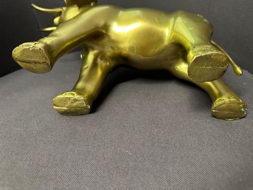 fig 5. A vintage cast brass elephant sculpture standing with its trunk raised high.