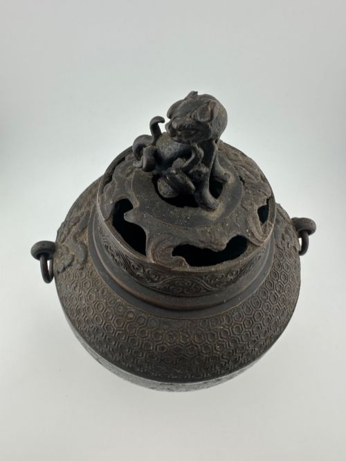 fig 6. A dark bronze globular tripod incense burner featuring colourful enamel lotus motifs, side ring handles, and a pierced lid with a seated Qilin finial.