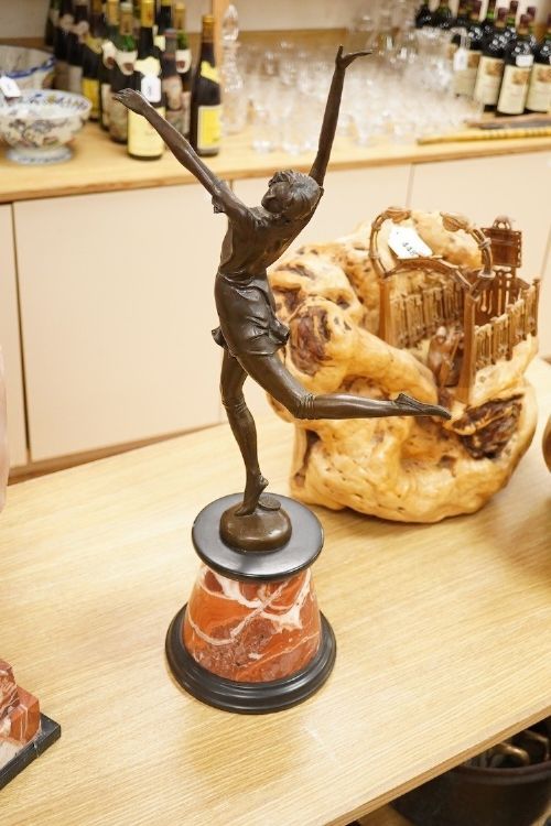 fig 4. A bronze sculpture depicting a female dancer in a dynamic pose, mounted on a round veined red marble plinth.