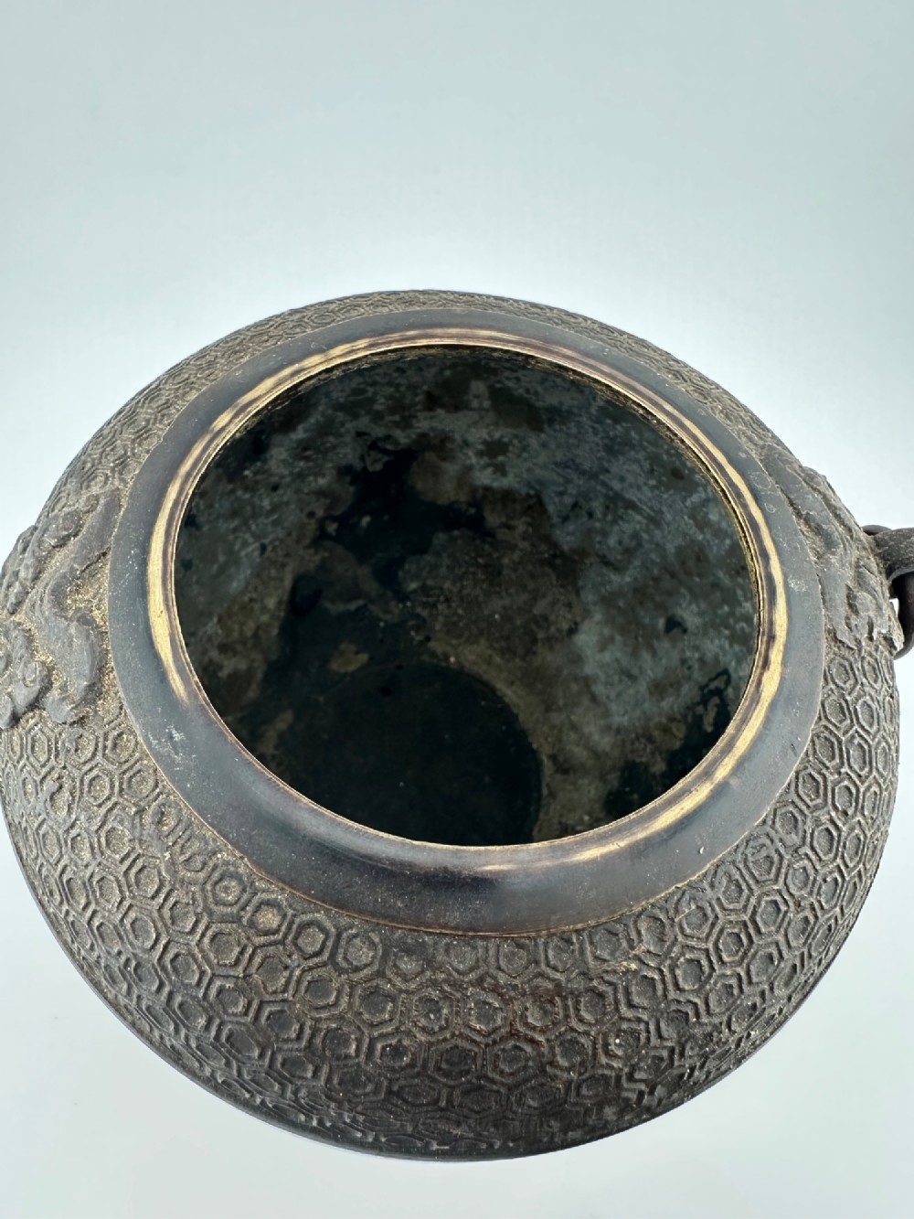 A 19th-century Chinese bronze tripod censer featuring polychrome cloisonne enamel floral motifs, side loop handles, and a lid topped with a Qilin finial. View VI