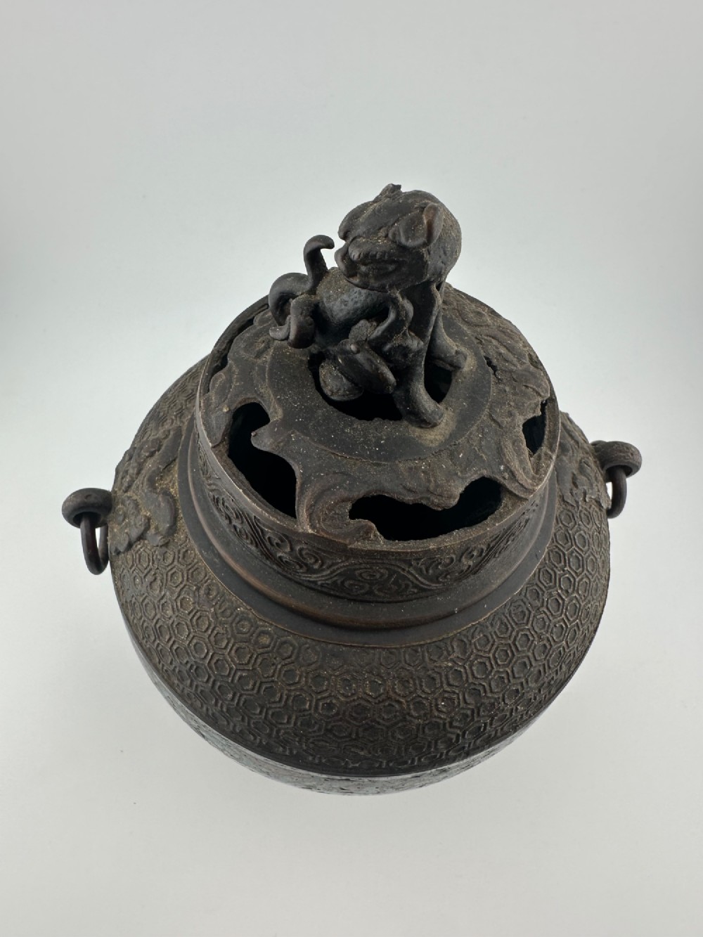 A 19th-century Chinese bronze tripod censer featuring polychrome cloisonne enamel floral motifs, side loop handles, and a lid topped with a Qilin finial. View VII