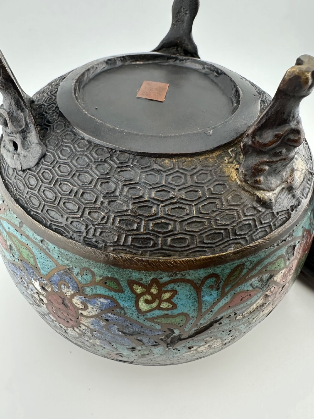 A 19th-century Chinese bronze tripod censer featuring polychrome cloisonne enamel floral motifs, side loop handles, and a lid topped with a Qilin finial. View XI