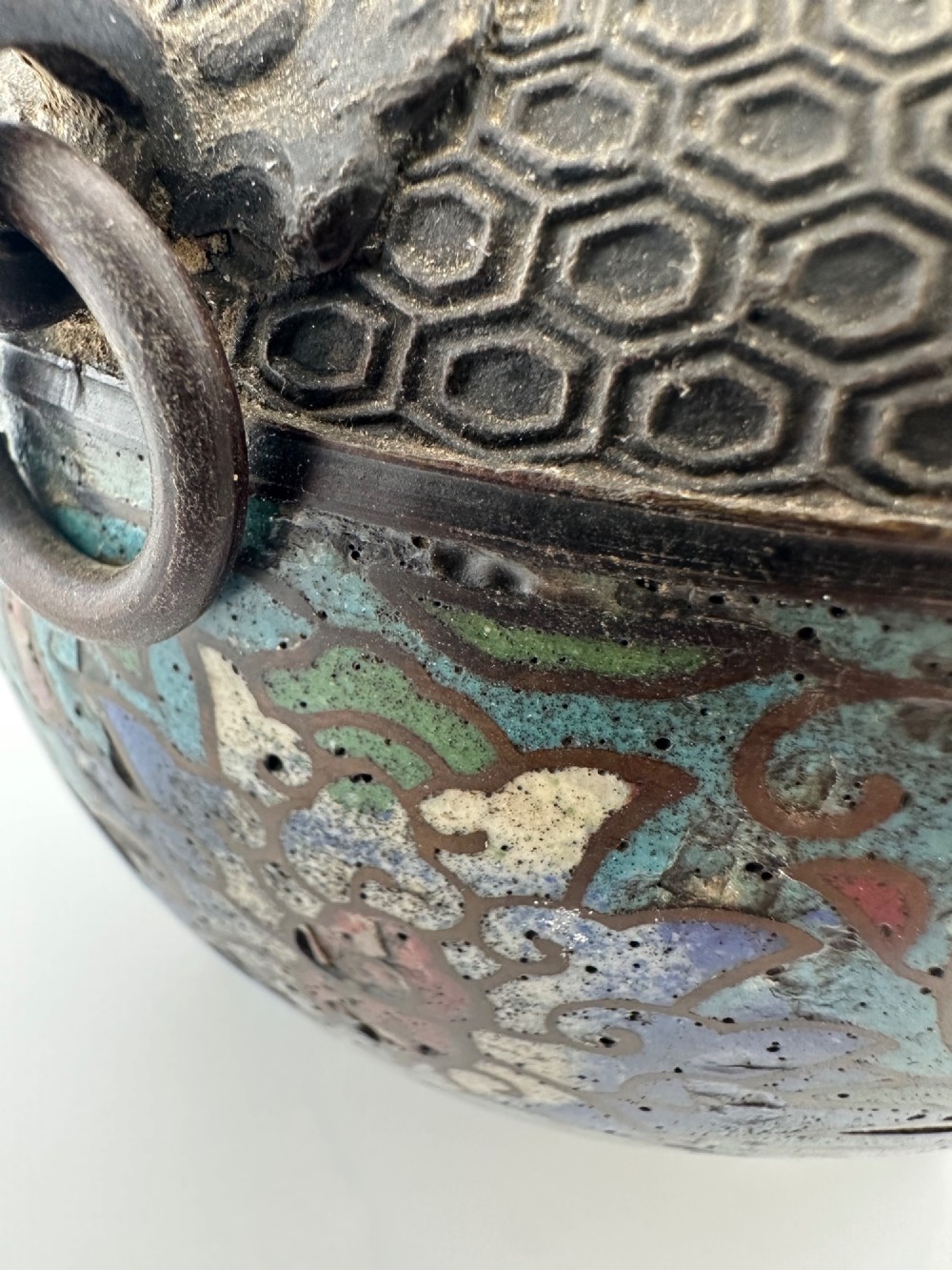 A 19th-century Chinese bronze tripod censer featuring polychrome cloisonne enamel floral motifs, side loop handles, and a lid topped with a Qilin finial. View XIII