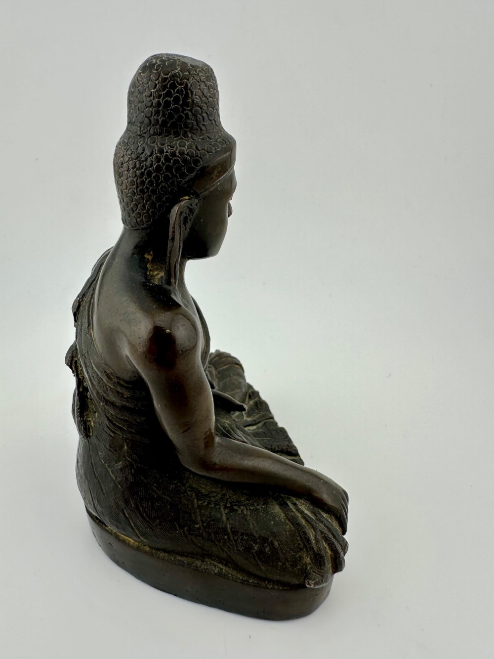 A 19th-century Burmese cast bronze seated Shakyamuni Buddha statue depicting the Bhumisparsha mudra with a dark patinated finish. View V