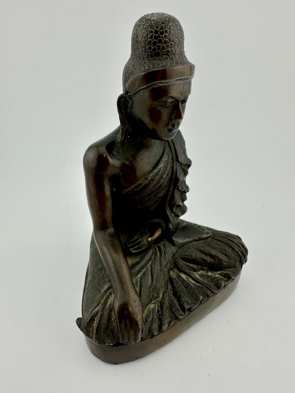 A 19th-century Burmese cast bronze seated Shakyamuni Buddha statue depicting the Bhumisparsha mudra with a dark patinated finish. View VI