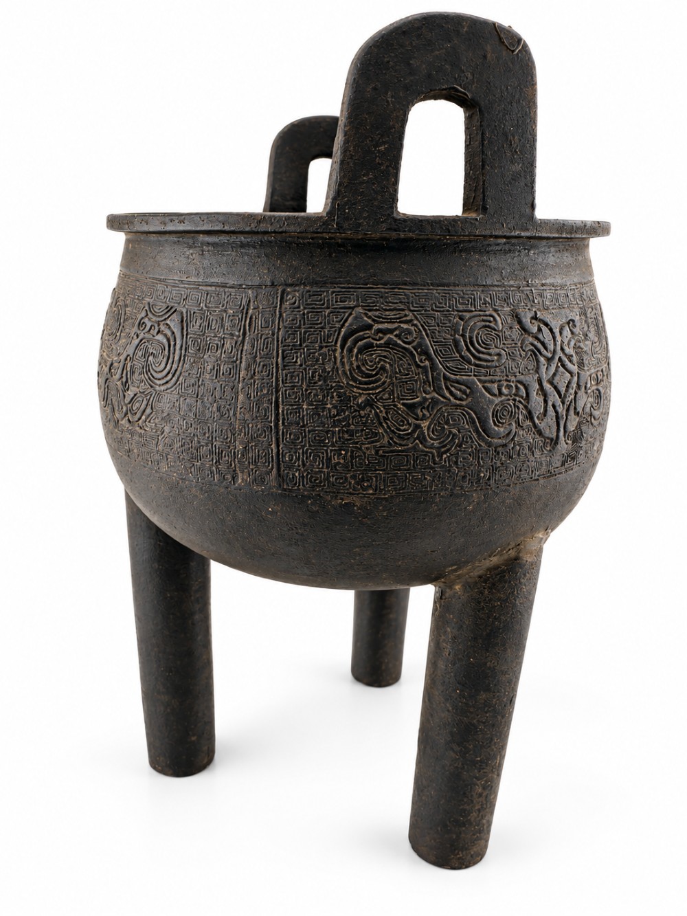 A dark patinated bronze tripod ding censer featuring three cylindrical legs, twin upright handles, and carved taotie mask relief decoration around the upper body. View VIII