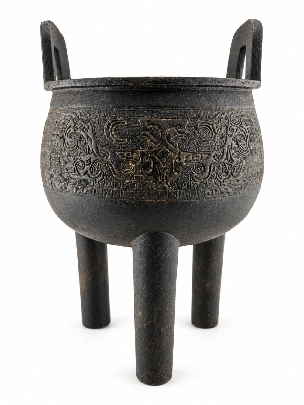 A dark patinated bronze tripod ding censer featuring three cylindrical legs, twin upright handles, and carved taotie mask relief decoration around the upper body.