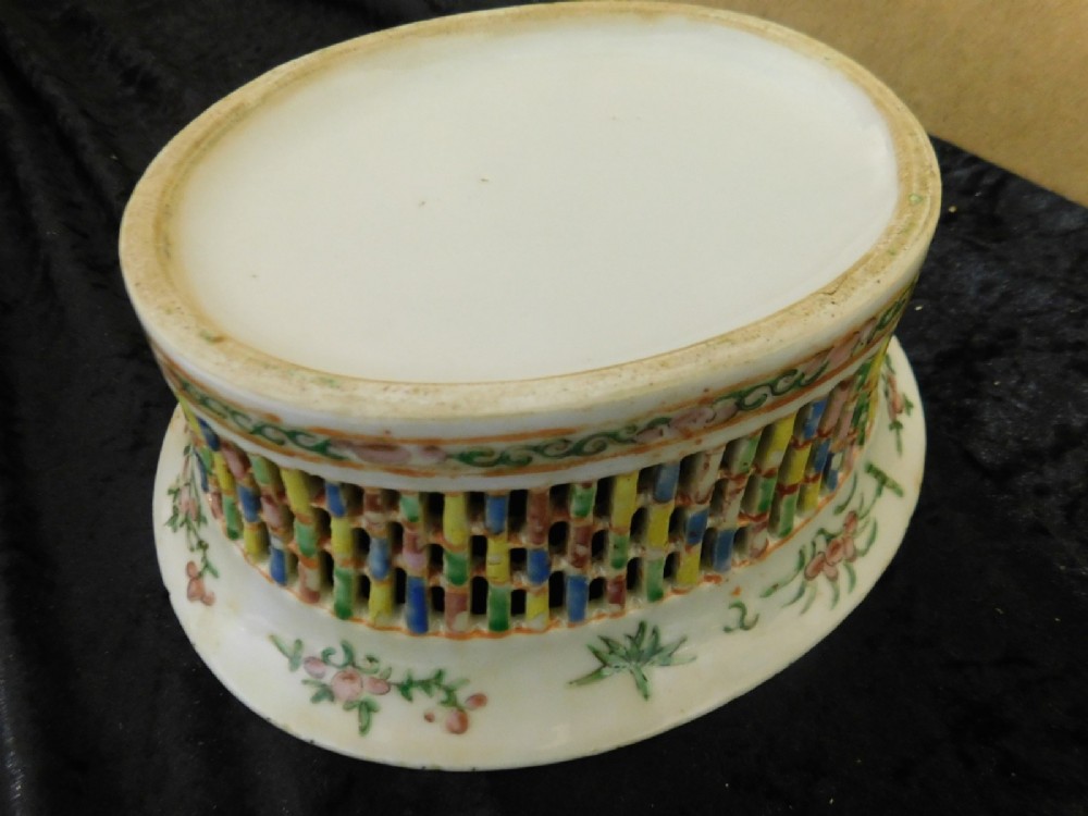 A 19th-century Chinese Famille Rose reticulated porcelain basket and matching pierced underplate decorated with polychrome floral and figurative motifs. View V