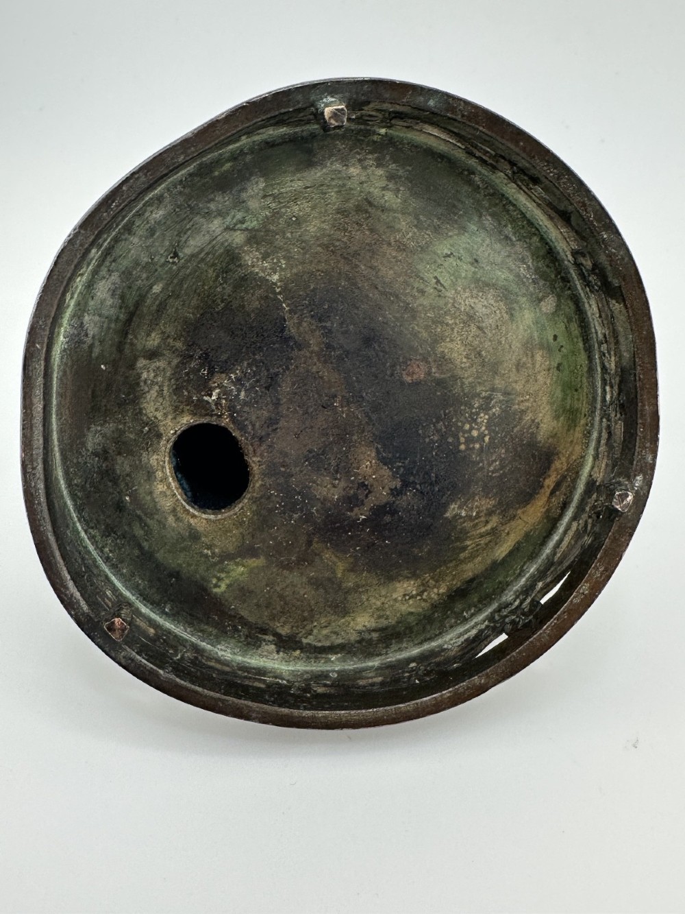 A dark patinated bronze tripod censer featuring raised loop handles, a decorative meander border, and a fitted lid with a standing Qilin finial. View X