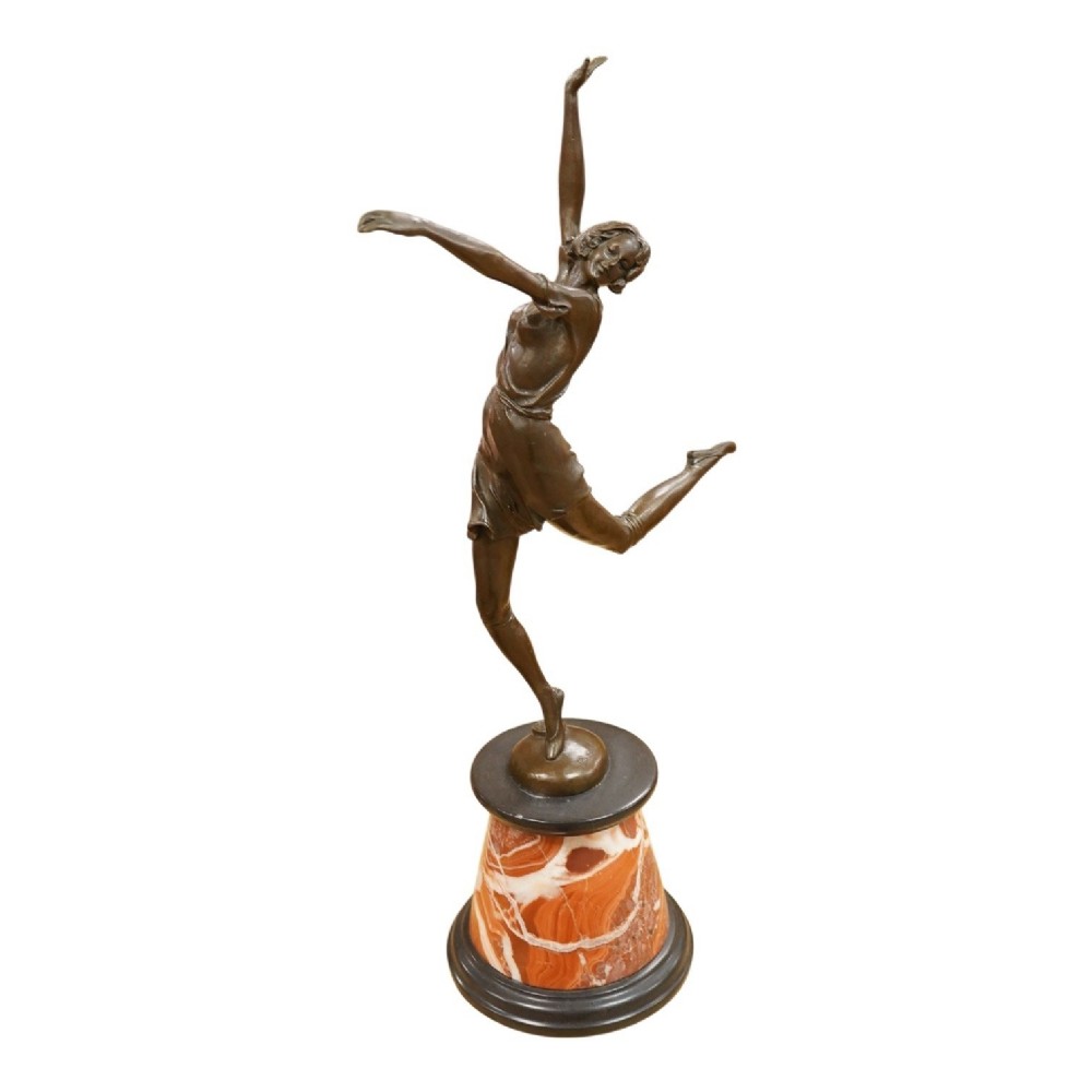 An Art Deco style bronze sculpture of a female dancer in mid-leap mounted on a rounded variegated orange marble base.