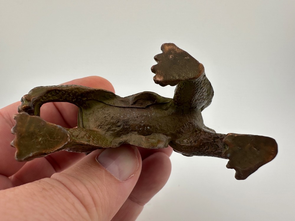 A small patinated dark brown bronze figure of a Chinese mythical beast, standing on four legs with an open mouth and raised tail. View VII