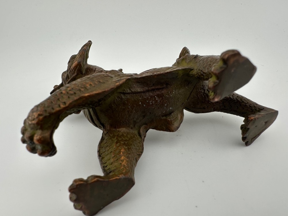 A small patinated dark brown bronze figure of a Chinese mythical beast, standing on four legs with an open mouth and raised tail. View VIII
