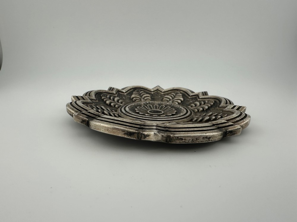 A lobed Chinese white metal dish with raised relief repousse lotus foliage and a central floral motif. View VI
