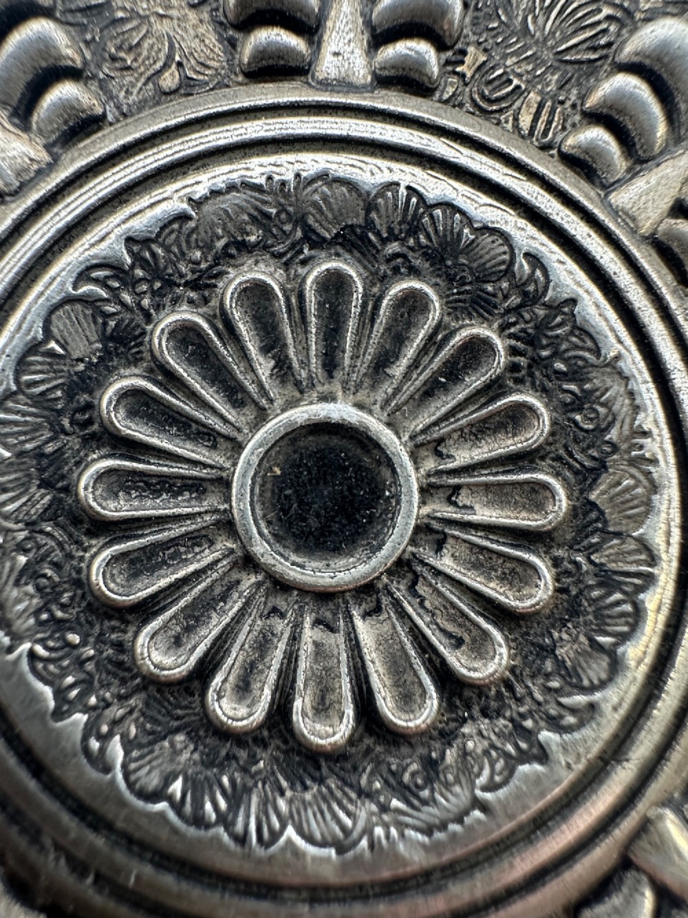 A lobed Chinese white metal dish with raised relief repousse lotus foliage and a central floral motif. View VIII