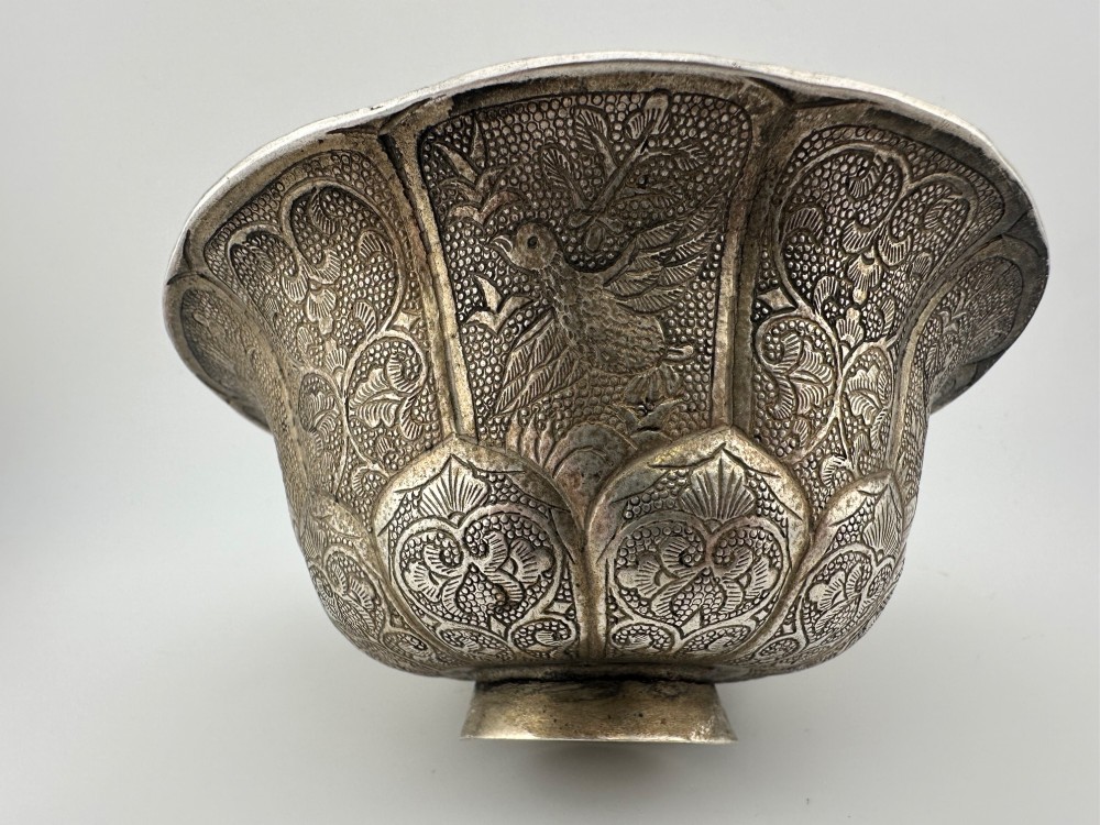 A lobed silver white metal bowl decorated with hand-chased panels of birds and flowers on a textured ground. View VIII