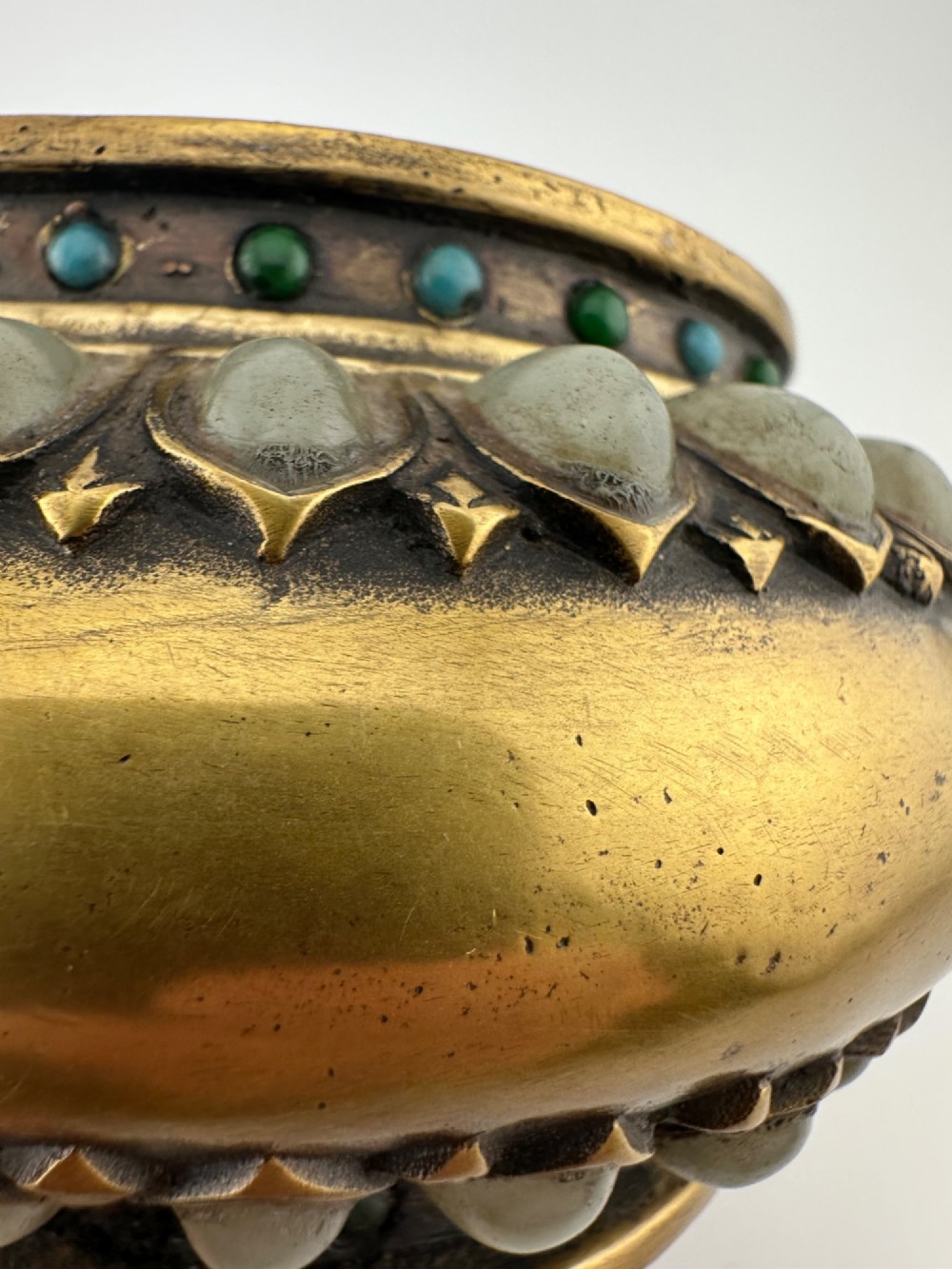 An antique gilded bronze Chinese censer featuring hardstone and jade cabochon inlays, beast-head handles, a pierced cover, and a matching carved stand. View VIII