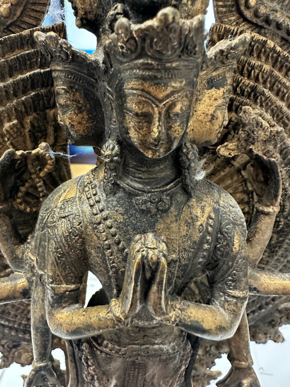 A dark bronze Tibetan sculpture depicting eleven-headed Avalokiteshvara with radiating arms set against a halo mandorla on a lotus pedestal. View VIII