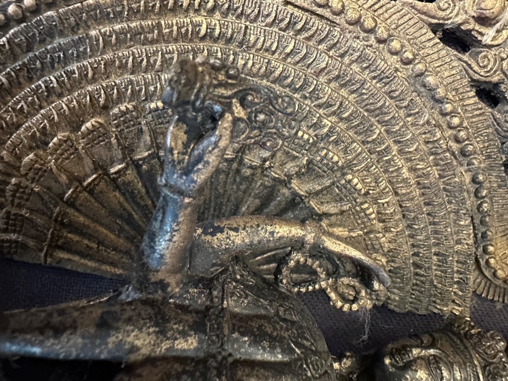 A dark bronze Tibetan sculpture depicting eleven-headed Avalokiteshvara with radiating arms set against a halo mandorla on a lotus pedestal. View XIV