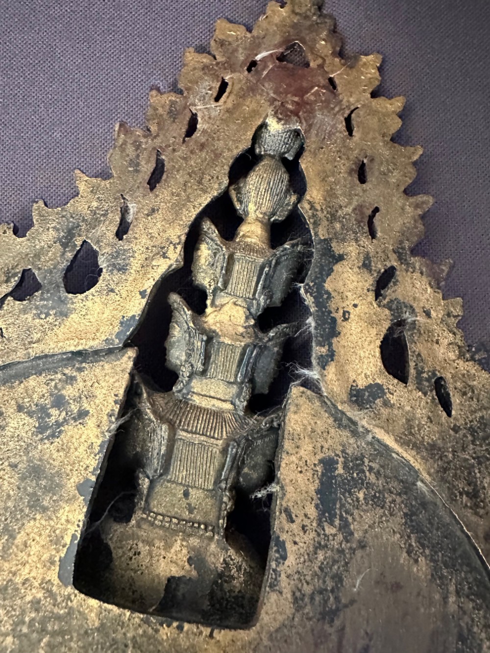 A dark bronze Tibetan sculpture depicting eleven-headed Avalokiteshvara with radiating arms set against a halo mandorla on a lotus pedestal. View XV