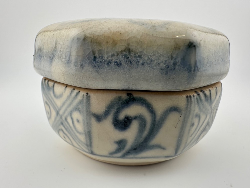 Small octagonal ceramic covered box featuring off-white glaze and hand-painted blue cobalt scroll motifs. View VII