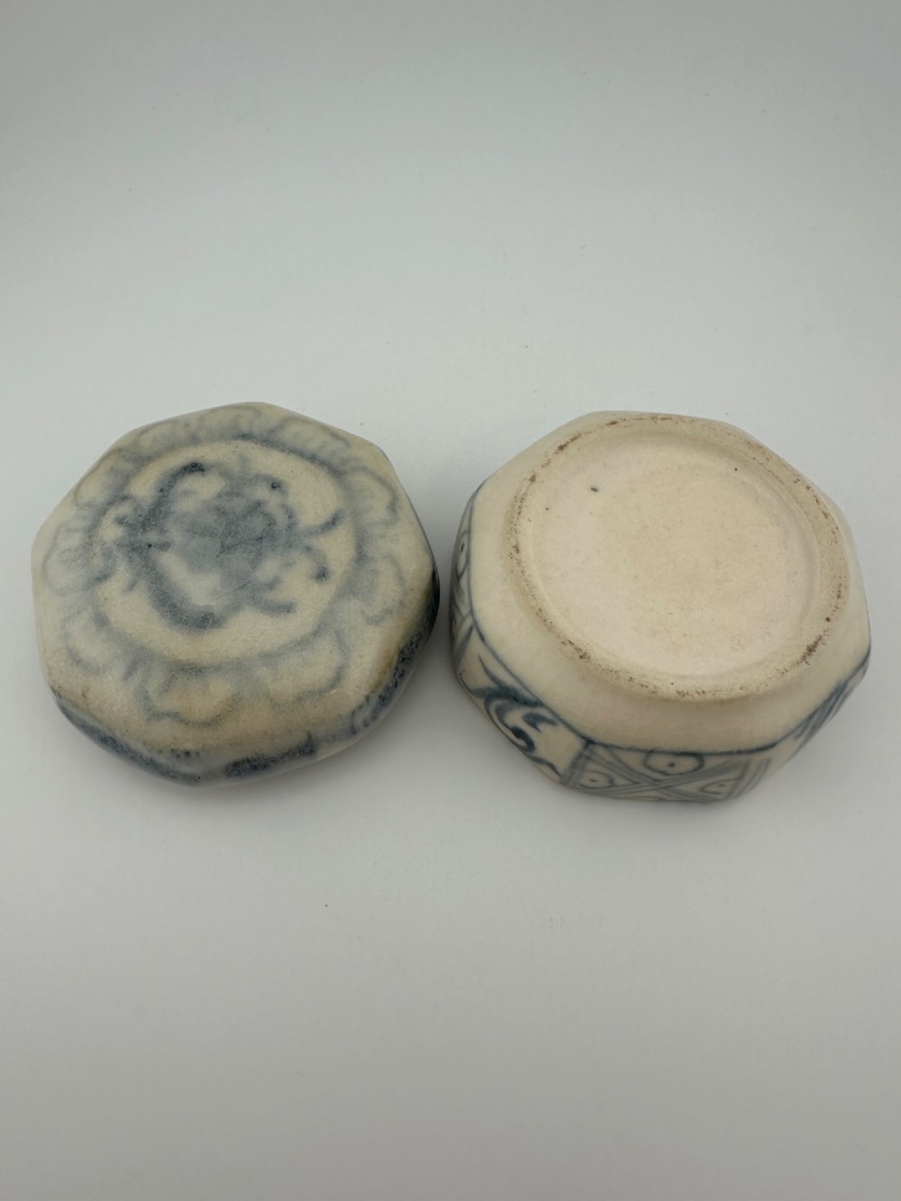 Small octagonal ceramic covered box featuring off-white glaze and hand-painted blue cobalt scroll motifs. View XIV
