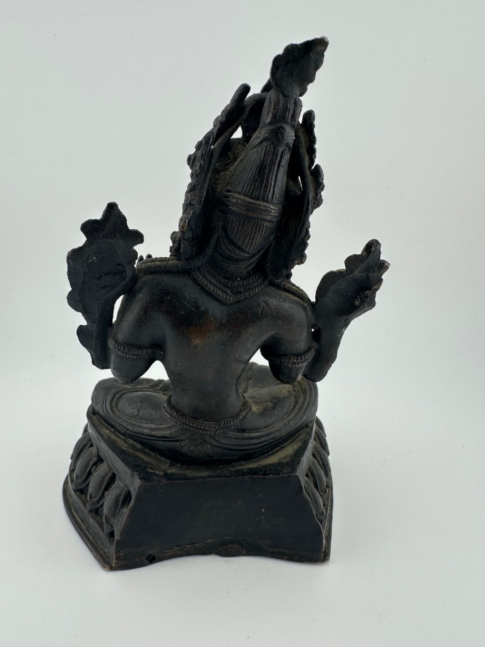 A dark bronze figure of the Buddhist deity Tara seated in lalitasana on an ornate lotus base. View VII
