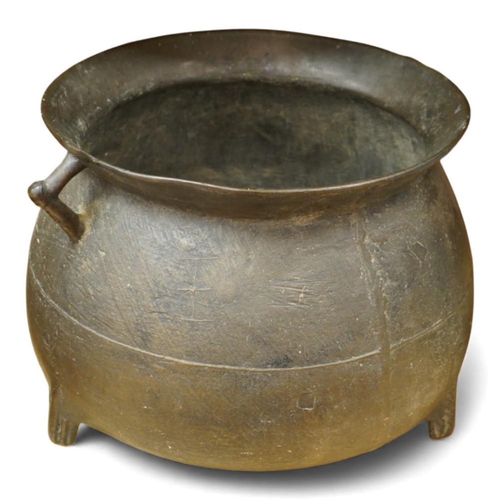 A 17th-century leaded bronze cauldron with a bulbous body, three short feet, angular side handles, and a dark patinated surface.