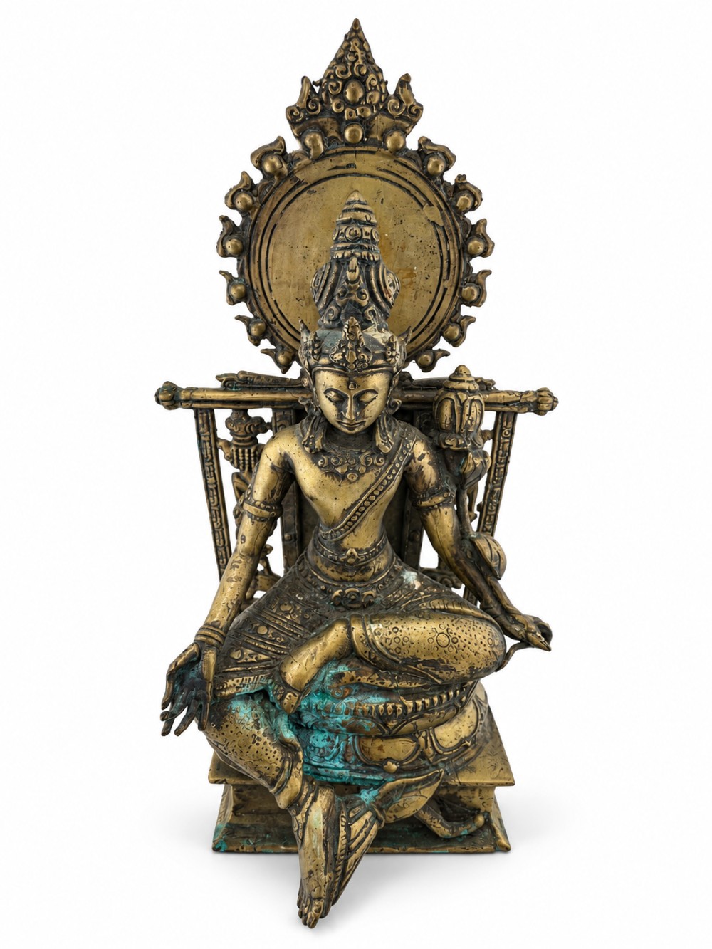 An antique cast bronze figure of Green Tara seated on an elaborate throne with a flaming halo backpiece and visible green patination.