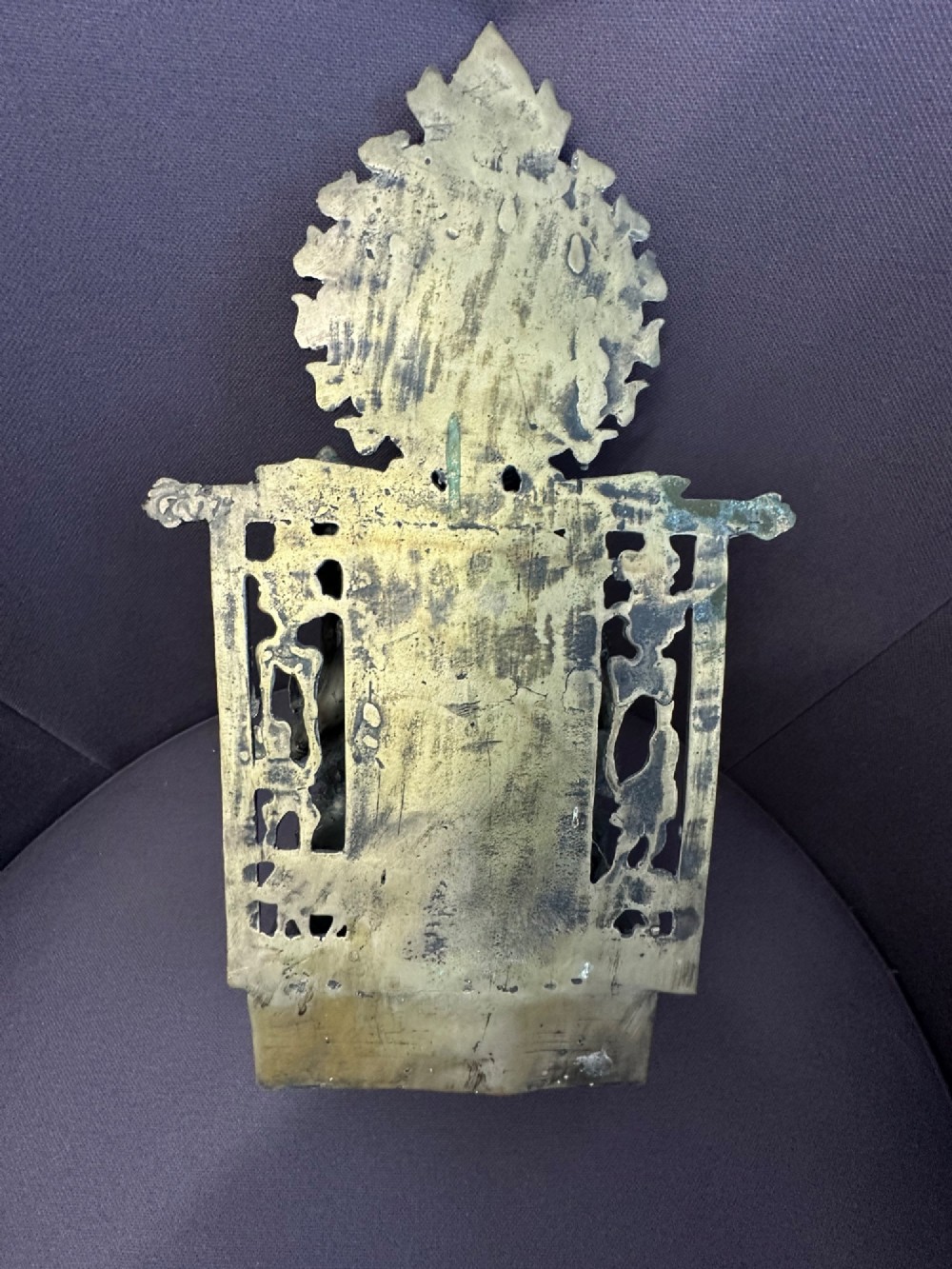 An antique cast bronze figure of Green Tara seated on an elaborate throne with a flaming halo backpiece and visible green patination. View VI