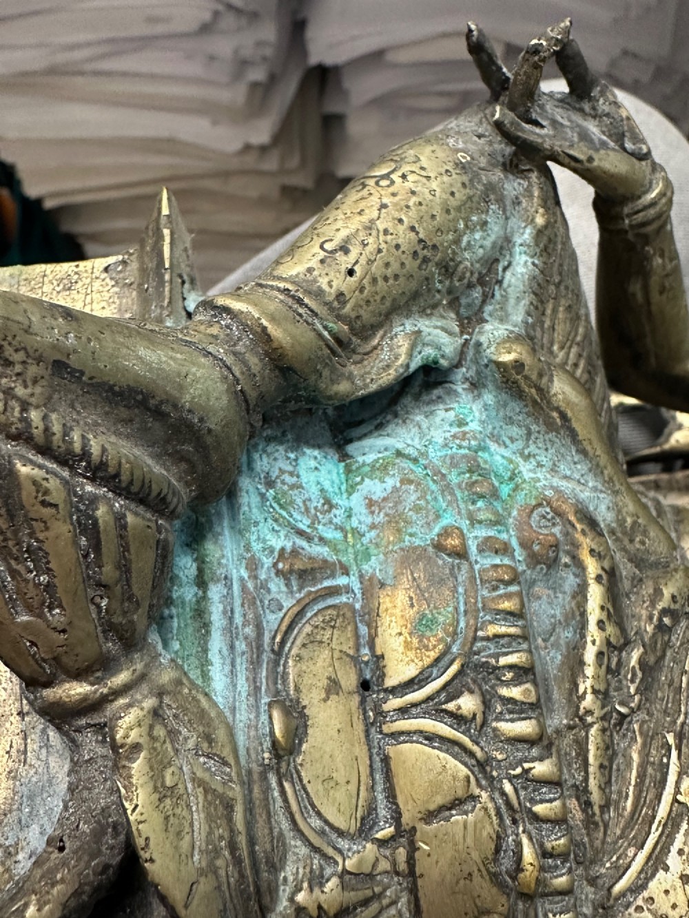 An antique cast bronze figure of Green Tara seated on an elaborate throne with a flaming halo backpiece and visible green patination. View XI