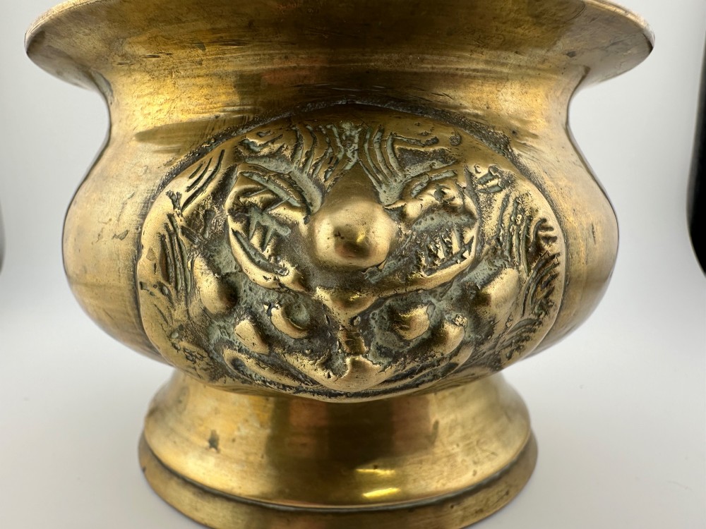 A rounded antique brass Chinese censer featuring a flared rim, pedestal base, and sculpted lion mask handles on either side. View XI