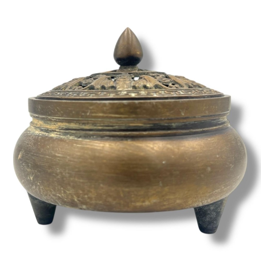A Chinese bronze tripod censer featuring a compressed circular body, three tapered feet, and a reticulated lotus lid topped with a pointed finial. View III