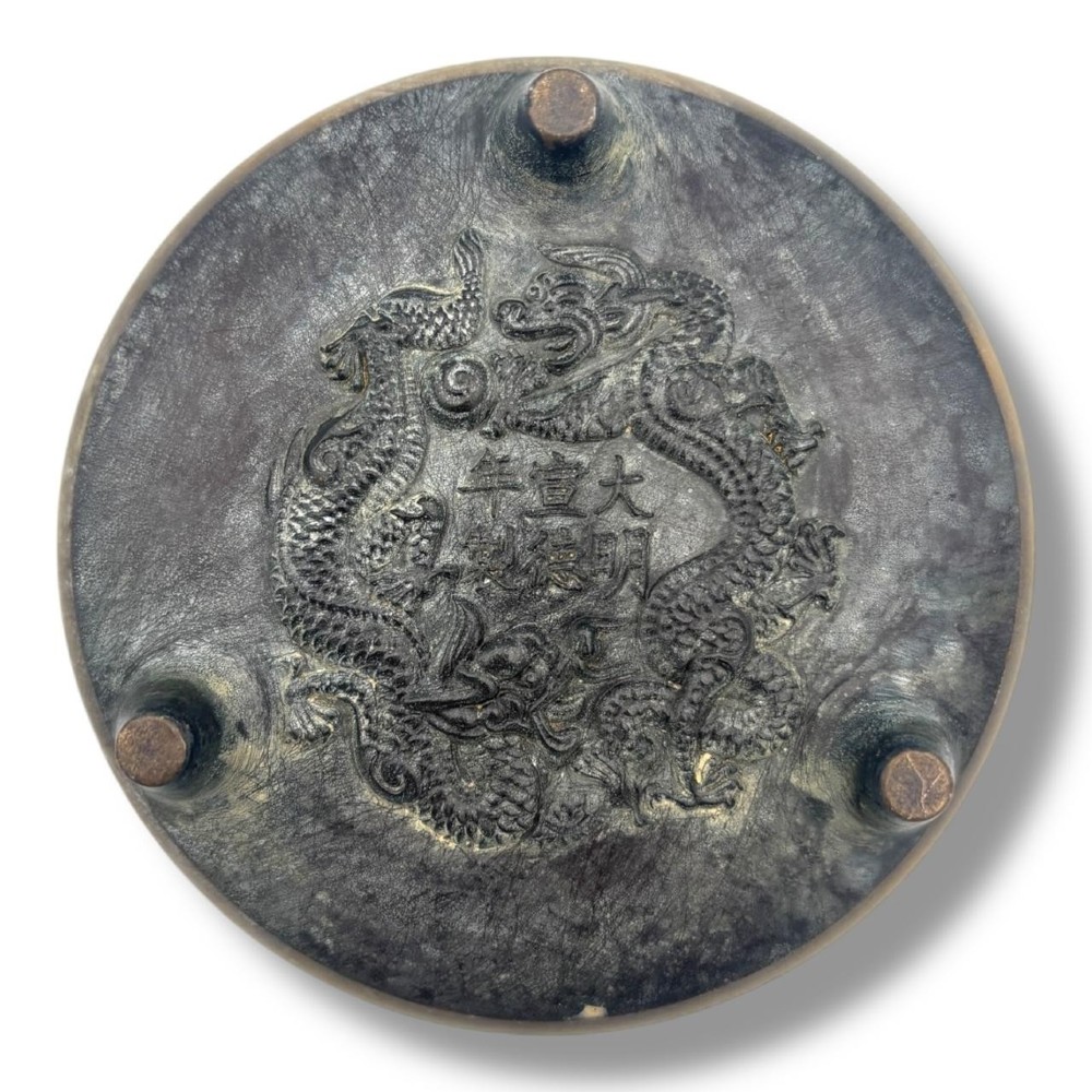 A Chinese bronze tripod censer featuring a compressed circular body, three tapered feet, and a reticulated lotus lid topped with a pointed finial. View IV