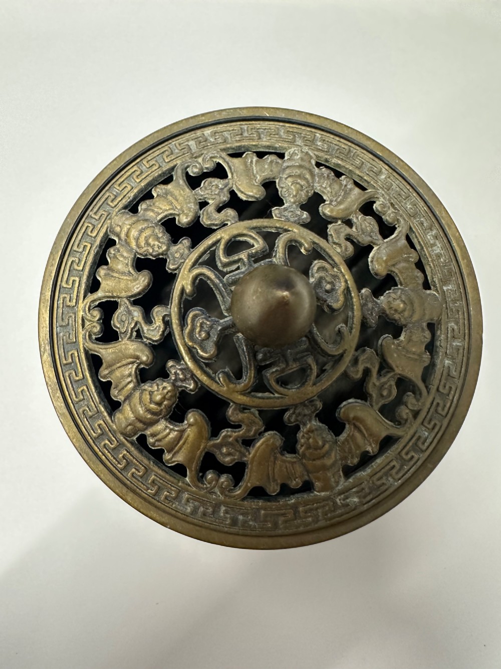 A Chinese bronze tripod censer featuring a compressed circular body, three tapered feet, and a reticulated lotus lid topped with a pointed finial. View IX