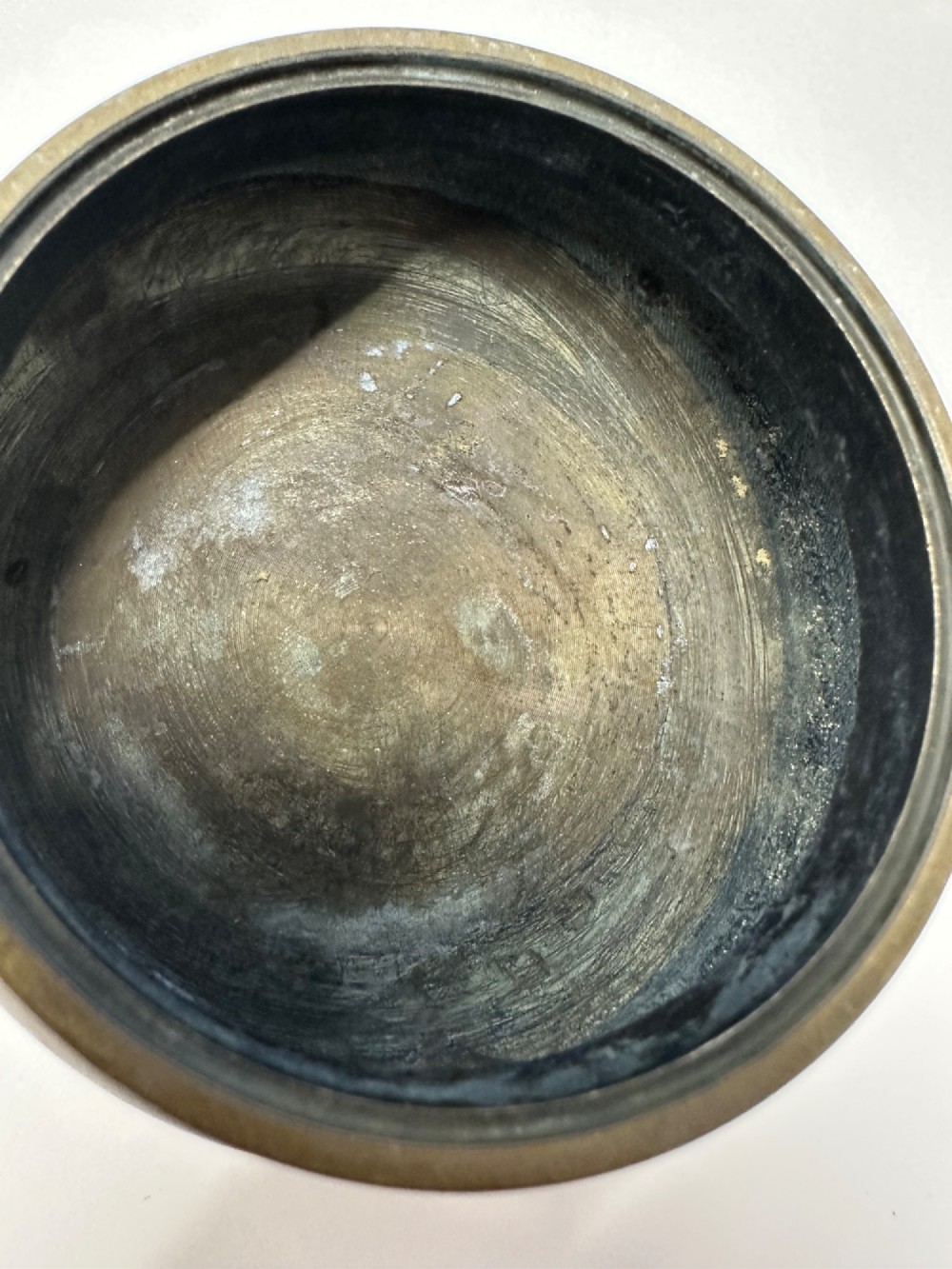 A Chinese bronze tripod censer featuring a compressed circular body, three tapered feet, and a reticulated lotus lid topped with a pointed finial. View X