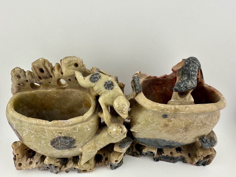 An antique Chinese carved soapstone double brush washer featuring two vessel shapes supported by carved animals and pierced rockwork in shades of mottled green, cream, and dark grey. View II