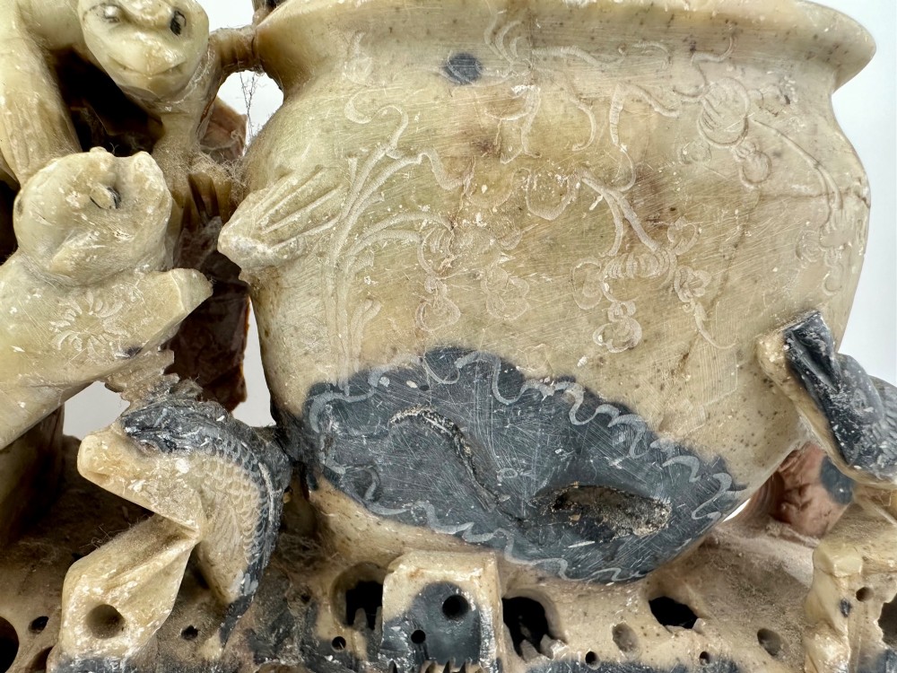 An antique Chinese carved soapstone double brush washer featuring two vessel shapes supported by carved animals and pierced rockwork in shades of mottled green, cream, and dark grey. View VI