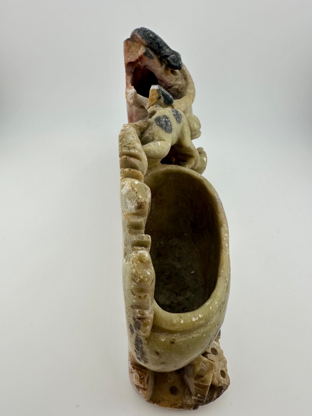 An antique Chinese carved soapstone double brush washer featuring two vessel shapes supported by carved animals and pierced rockwork in shades of mottled green, cream, and dark grey. View XI