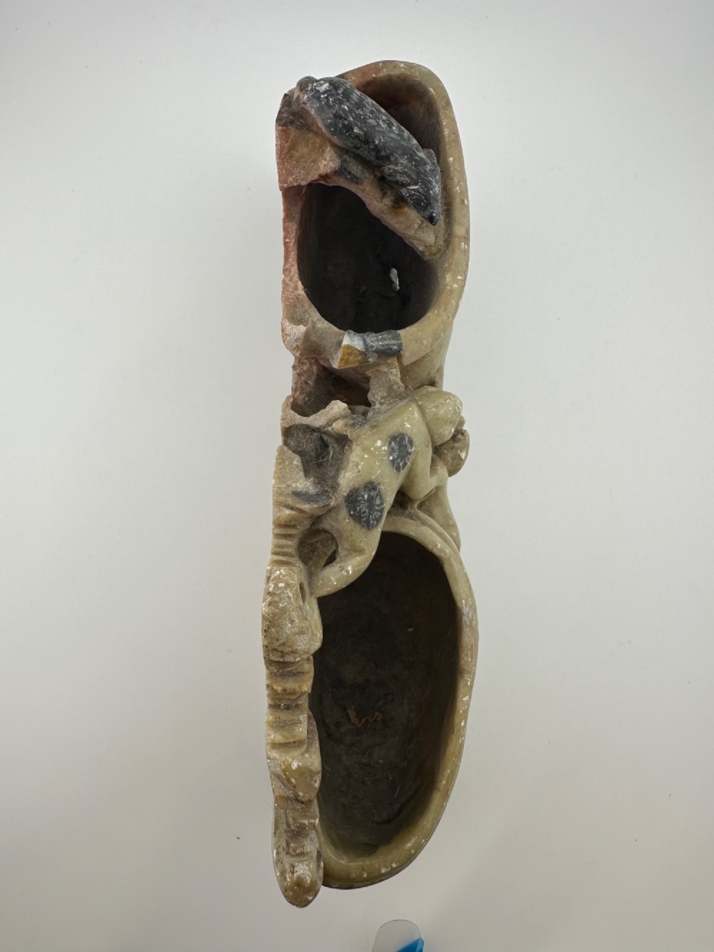 An antique Chinese carved soapstone double brush washer featuring two vessel shapes supported by carved animals and pierced rockwork in shades of mottled green, cream, and dark grey. View XII