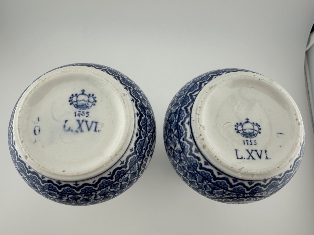 A pair of antique blue and white ceramic vases featuring central pastoral vignettes framed by elaborate scrollwork patterns. View II