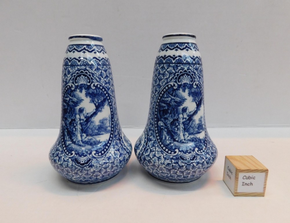 A pair of antique blue and white ceramic vases featuring central pastoral vignettes framed by elaborate scrollwork patterns. View V