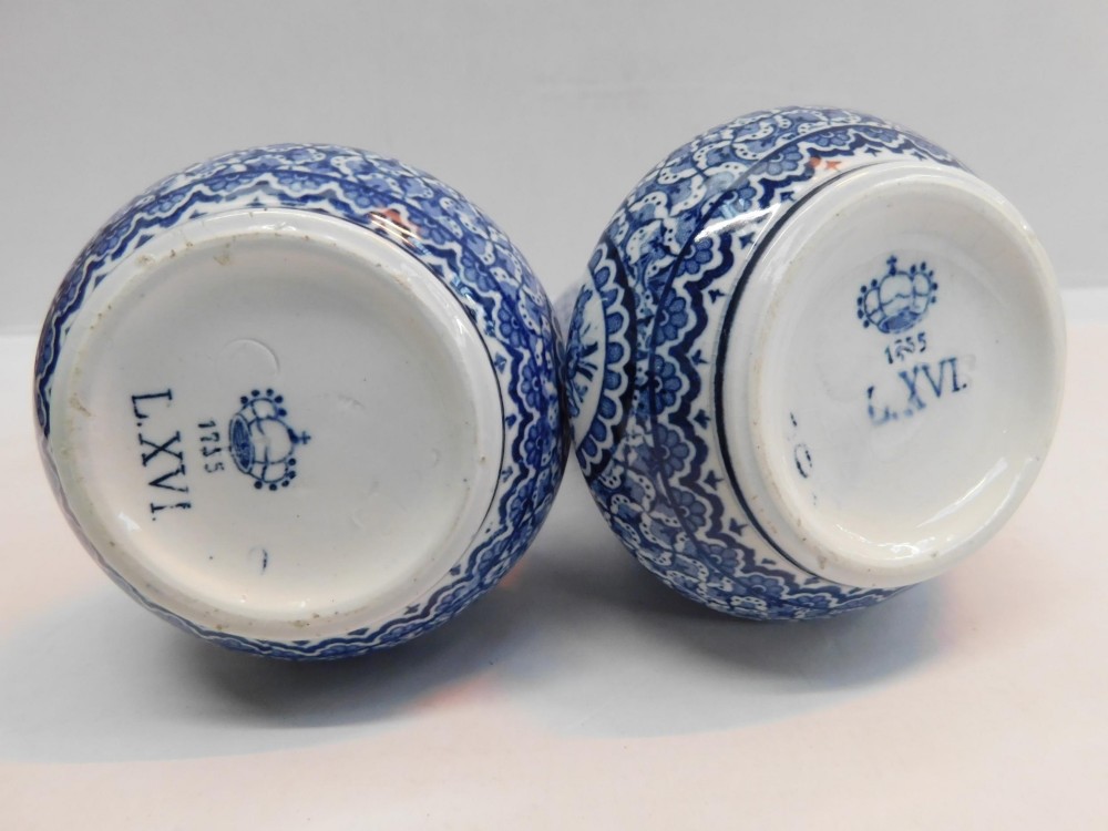 A pair of antique blue and white ceramic vases featuring central pastoral vignettes framed by elaborate scrollwork patterns. View VI
