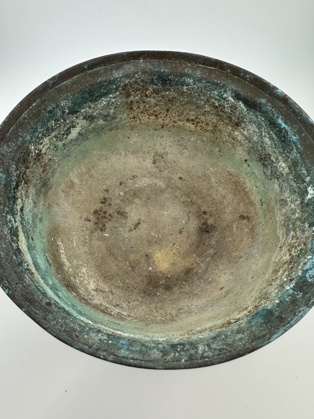 A pair of antique Chinese cast bronze footed bowls decorated with etched bird and lotus leaf motifs beneath key-fret rim borders. View VI